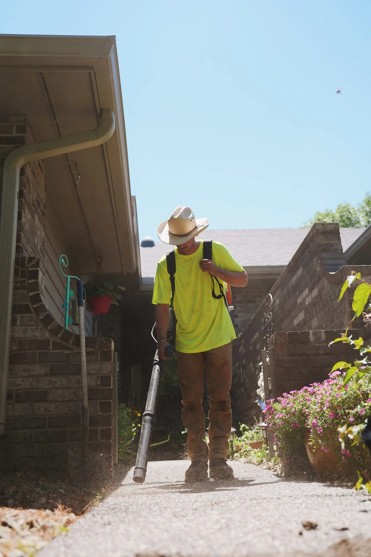 Crew member clearing a walkway with a blower