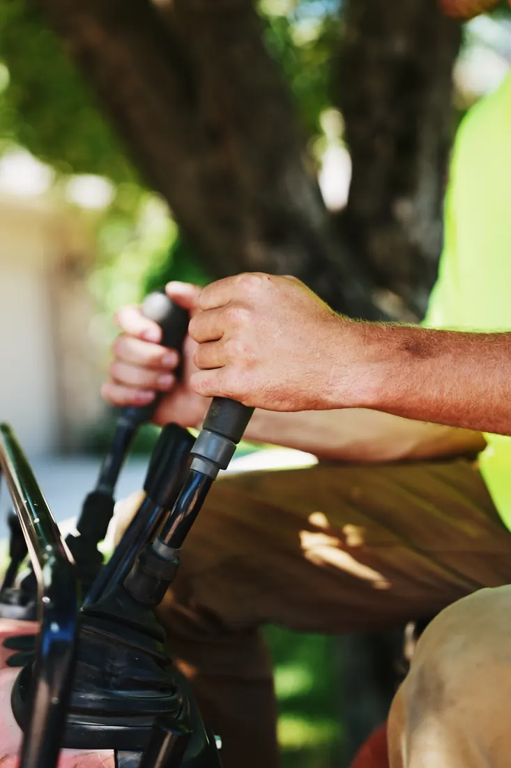 Close-up of a crew member's hands working the equipment controls