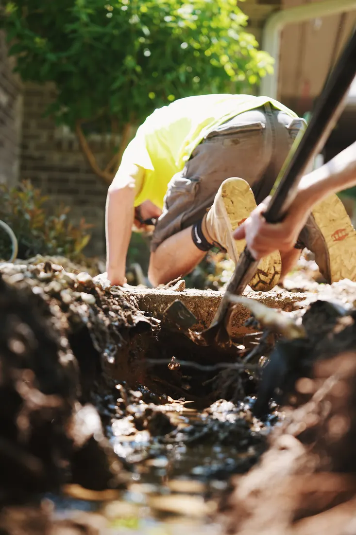 Crew member setting a timber into the trench by hand