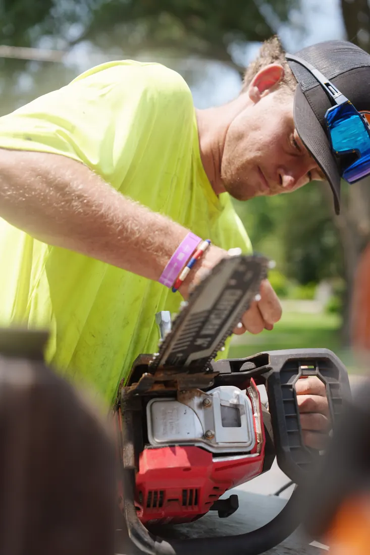 Crew member servicing the mower before the route