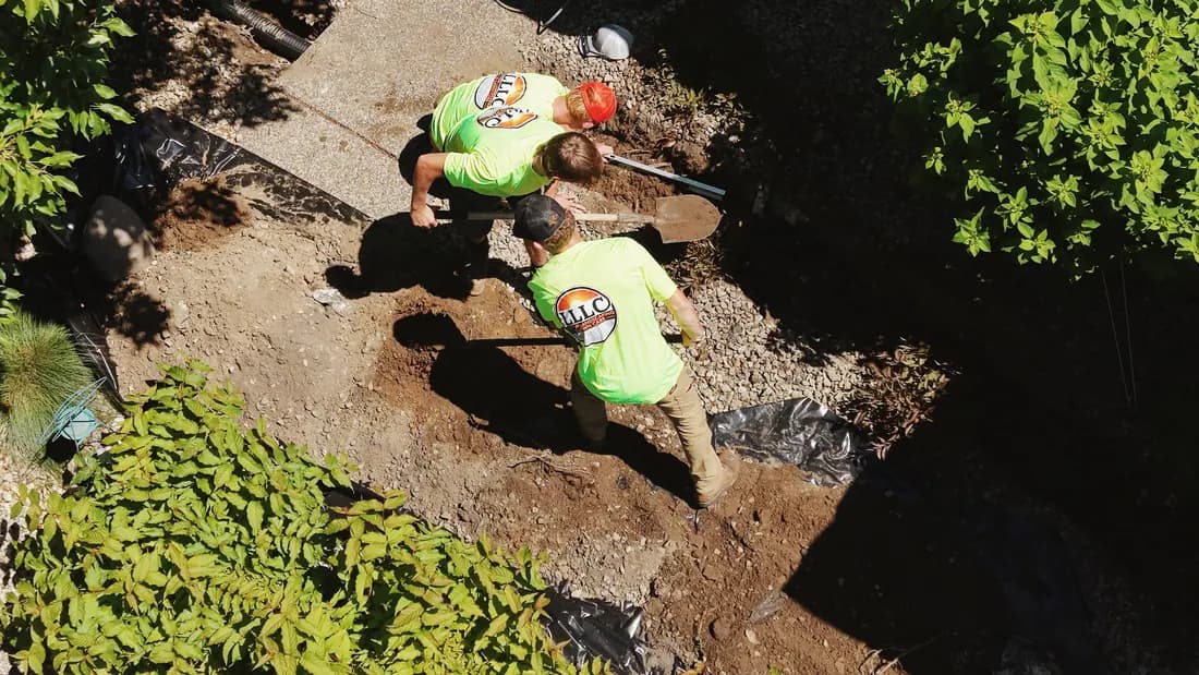 Overhead view of two crew members moving timbers up the slope