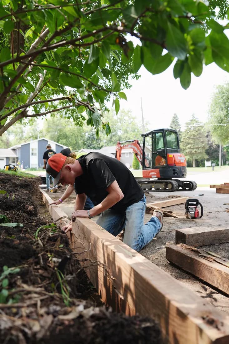 Crew member marking a timber before the cut, excavator behind